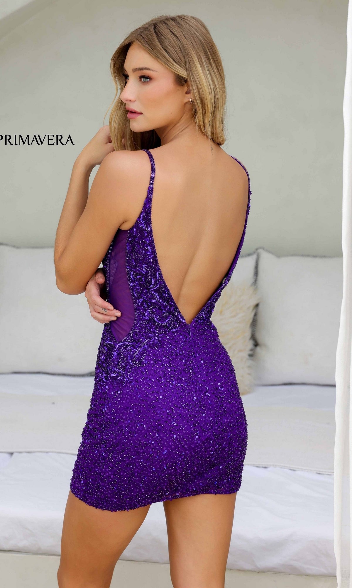 A woman in the Short Homecoming Dress 4245 by Primavera, featuring a purple v-neckline design.